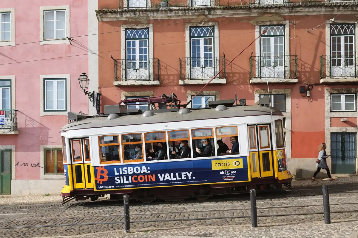 A yellow Lisbon tram passing Largo de Santa Luzia in the Alfama district