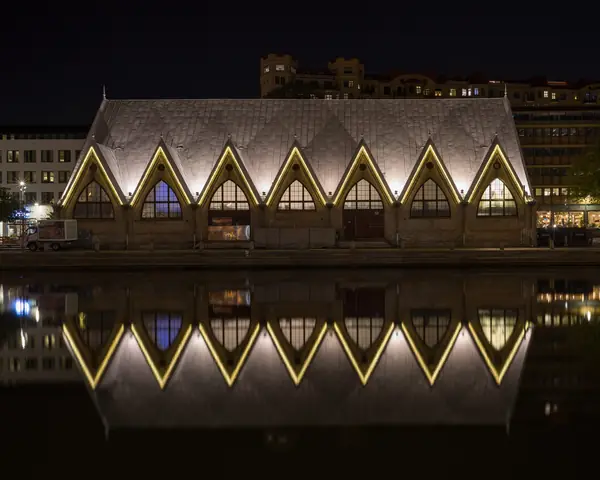 Feskekôrka, Gothenburg's historic fish-market hall, lit up at night and reflected in the canal