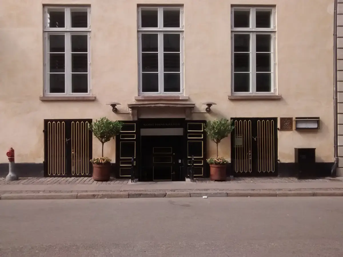 The street entrance of Kong Hans Kælder in Copenhagen, between two potted trees